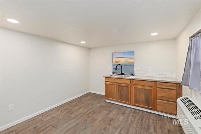 bar featuring hardwood / wood-style flooring, a wall unit AC, and sink