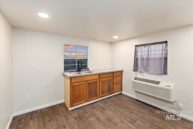 kitchen featuring a wall mounted air conditioner, dark hardwood / wood-style floors, and sink