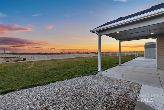 yard at dusk with a patio area