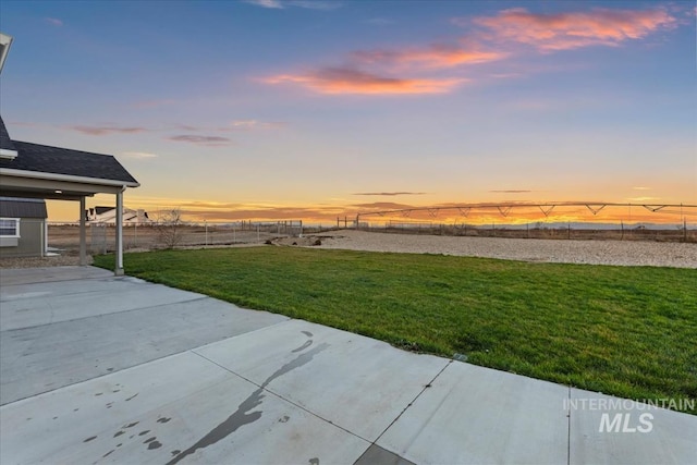 yard at dusk featuring a patio area