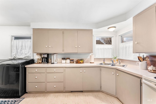 kitchen with electric range, a sink, light countertops, stove, and light floors