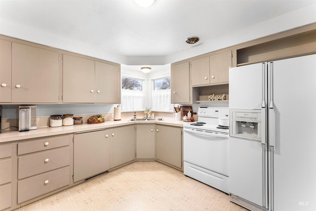 kitchen with open shelves, a sink, light countertops, light floors, and white appliances