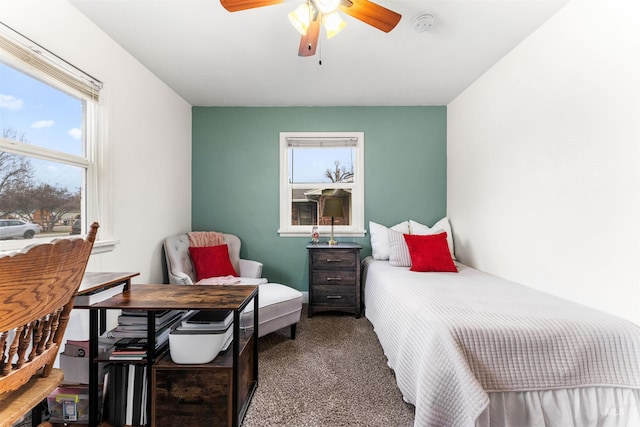 carpeted bedroom featuring multiple windows and ceiling fan