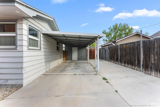 exterior space with fence, driveway, and an attached carport