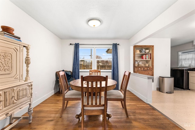 dining room with baseboards and wood finished floors