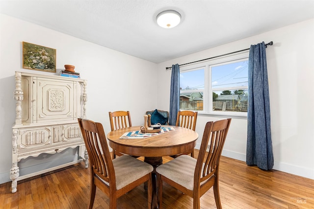 dining area featuring baseboards and light wood-style floors