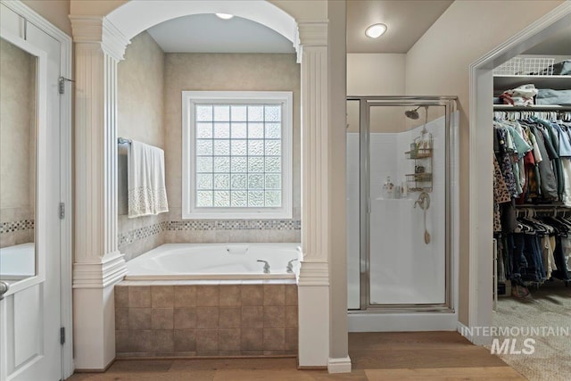 bathroom featuring hardwood / wood-style flooring, ornate columns, and independent shower and bath