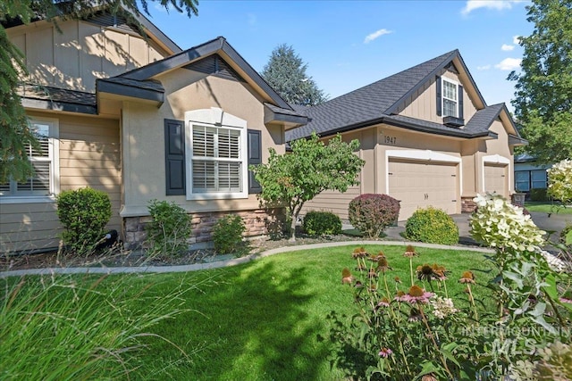 view of front of home with a garage and a front lawn