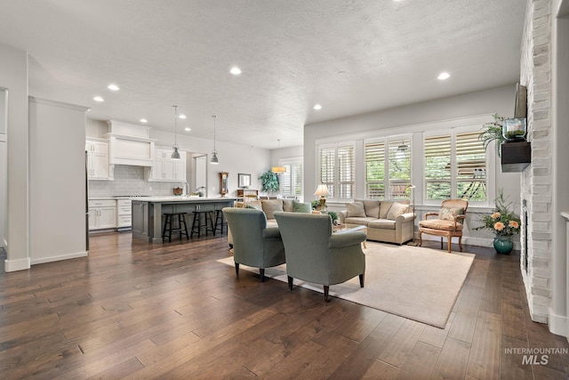 6922 N Agrarian, Meridian, ID 83646 - living room featuring recessed lighting, a textured ceiling, dark wood-type flooring, and a brick fireplace