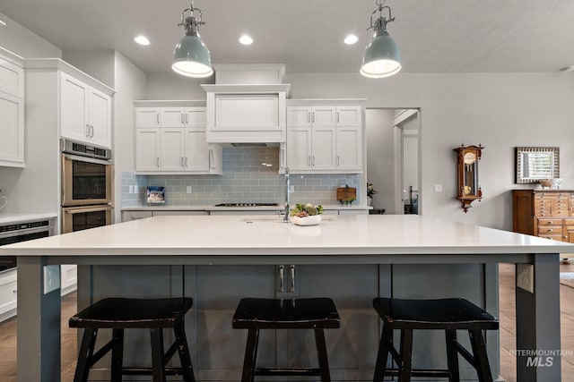 6922 N Agrarian, Meridian, ID 83646 - kitchen featuring stainless steel appliances, tasteful backsplash, white cabinetry, light countertops, and pendant lighting
