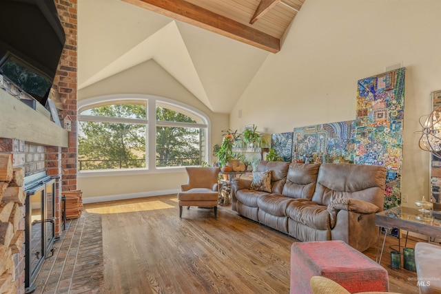 living room featuring hardwood / wood-style floors, high vaulted ceiling, a fireplace, and beam ceiling