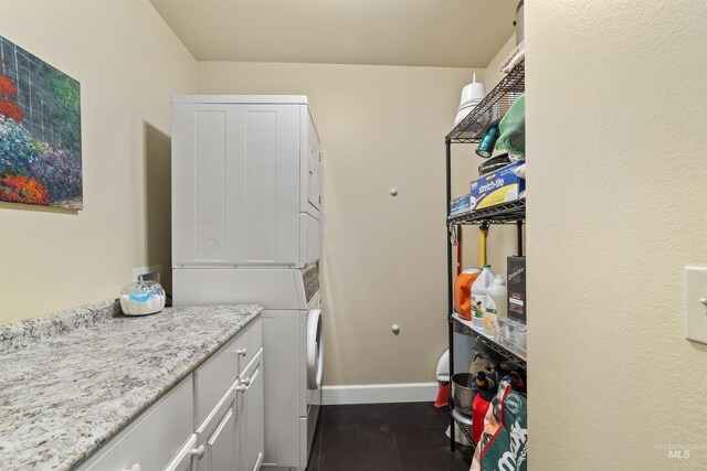 washroom featuring cabinets and stacked washer / drying machine