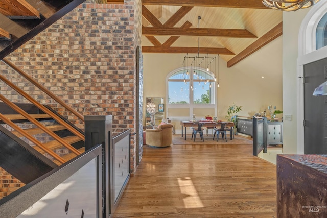 interior space with high vaulted ceiling, a notable chandelier, hardwood / wood-style floors, and beamed ceiling