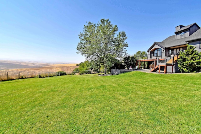 view of yard featuring a wooden deck and a rural view