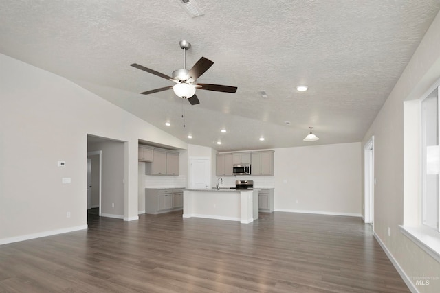 unfurnished living room with ceiling fan, dark hardwood / wood-style floors, sink, vaulted ceiling, and a textured ceiling