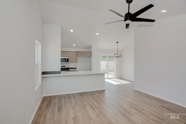 unfurnished living room featuring sink, ceiling fan, and light hardwood / wood-style flooring