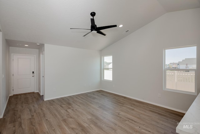 spare room featuring lofted ceiling, light hardwood / wood-style floors, and ceiling fan