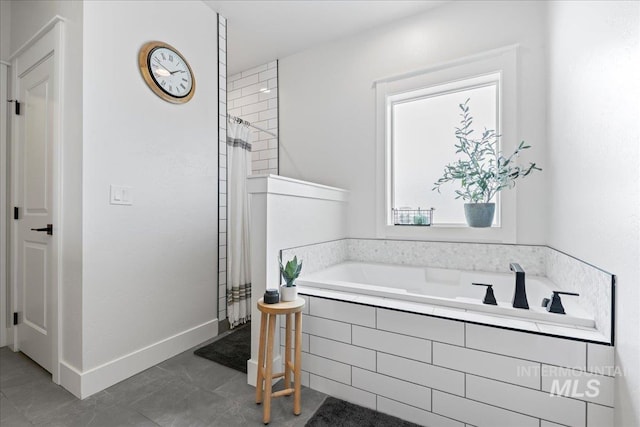 bathroom with tile patterned flooring, a tile shower, baseboards, and a bath