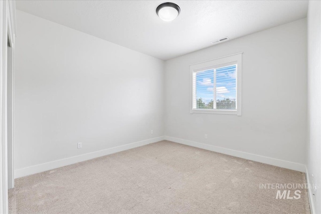 empty room with light carpet, visible vents, and baseboards