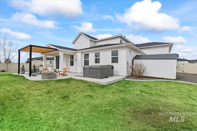 back of property with a storage shed, a hot tub, a patio, an outbuilding, and a yard