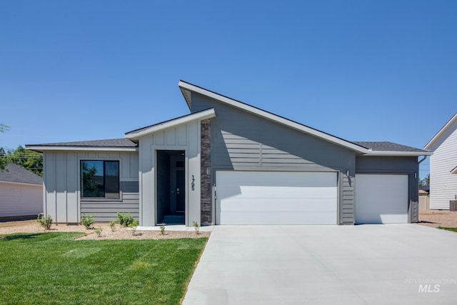 view of front of house featuring a garage, concrete driveway, board and batten siding, and a front yard