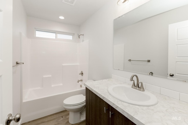 full bathroom featuring toilet, wood finished floors, bathtub / shower combination, vanity, and recessed lighting