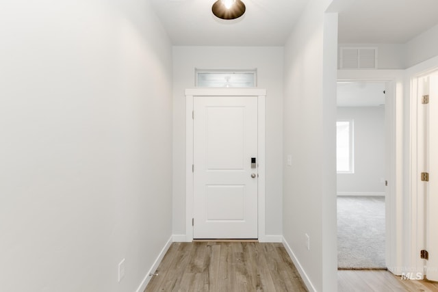 doorway to outside featuring light wood-style floors, baseboards, and visible vents