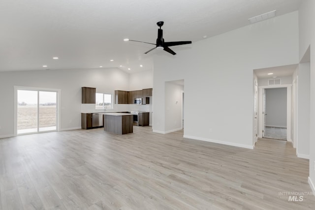 unfurnished living room featuring baseboards, light wood-style flooring, high vaulted ceiling, and a ceiling fan