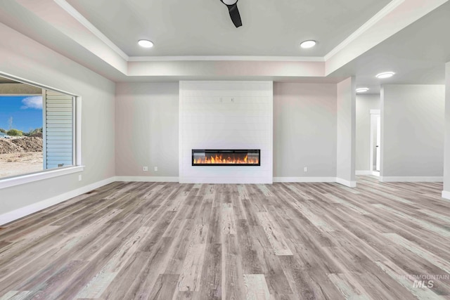 unfurnished living room with crown molding, a fireplace, and light wood-type flooring