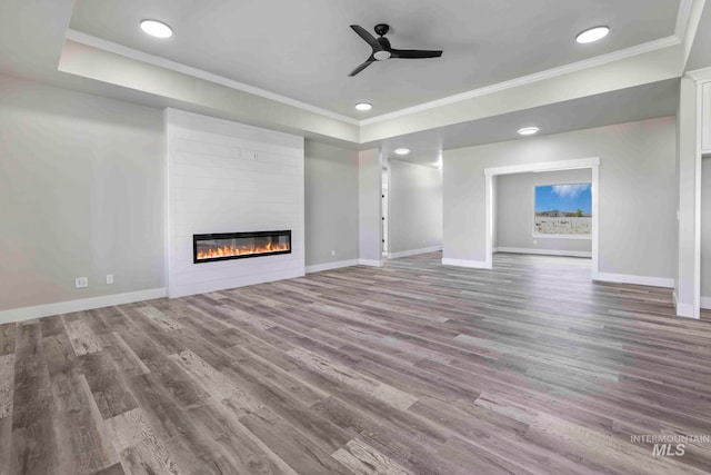 unfurnished living room with ceiling fan, wood-type flooring, and ornamental molding