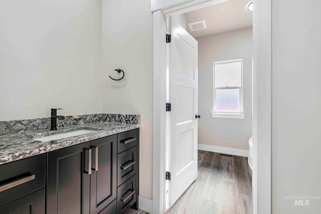 bathroom with vanity, toilet, and hardwood / wood-style flooring