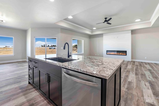 kitchen featuring light hardwood / wood-style flooring, dishwasher, sink, and an island with sink