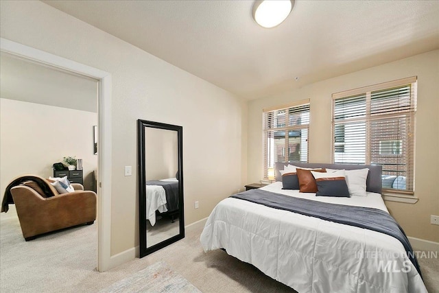 bedroom featuring light colored carpet and lofted ceiling