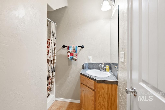 720 E Main St, Jerome, ID 83338 - full bath featuring wood finished floors, vanity, a shower stall, and baseboards