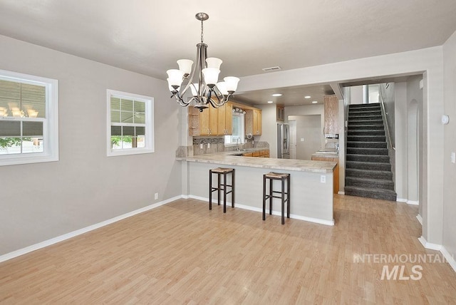 720 E Main St, Jerome, ID 83338 - kitchen with freestanding refrigerator, light countertops, a chandelier, and a peninsula