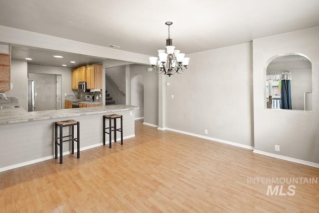 720 E Main St, Jerome, ID 83338 - kitchen with appliances with stainless steel finishes, light wood-style flooring, arched walkways, baseboards, and recessed lighting