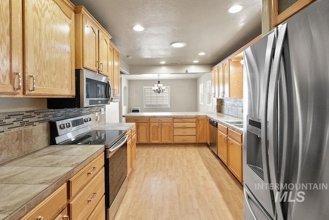 720 E Main St, Jerome, ID 83338 - kitchen featuring stainless steel appliances, a chandelier, light wood-type flooring, a peninsula, and recessed lighting