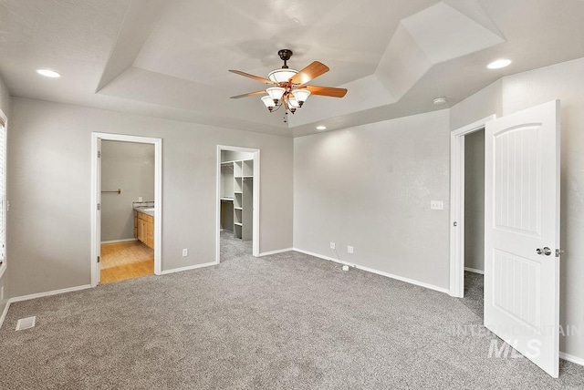 720 E Main St, Jerome, ID 83338 - unfurnished bedroom with a raised ceiling, light carpet, a walk in closet, baseboards, and connected bathroom