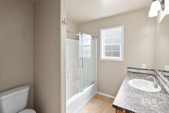 720 E Main St, Jerome, ID 83338 - bathroom featuring wood finished floors, vanity, toilet, combined bath / shower with glass door, and baseboards