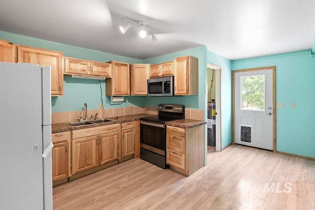 720 E Main St, Jerome, ID 83338 - kitchen featuring stainless steel appliances, a sink, light wood finished floors, and dark countertops
