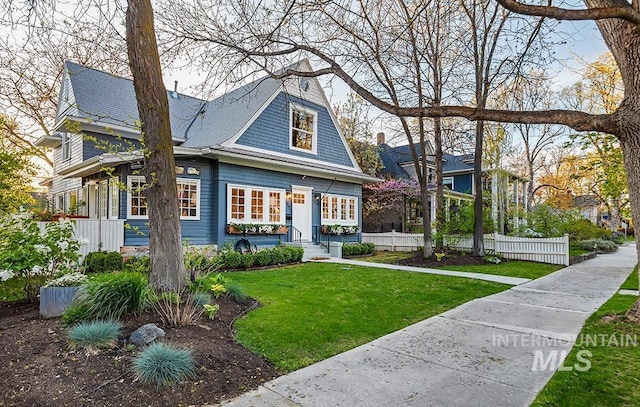 view of front facade featuring a front yard and fence