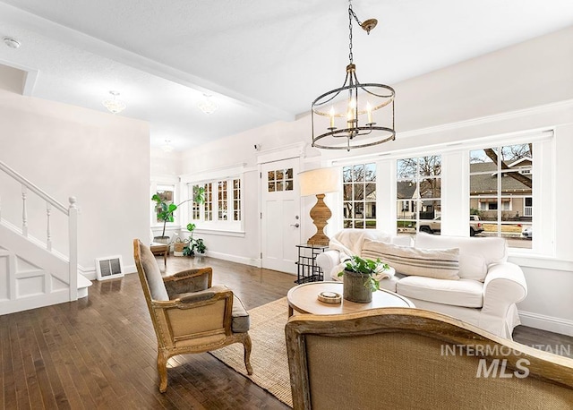 living area featuring stairway, visible vents, hardwood / wood-style flooring, and a healthy amount of sunlight