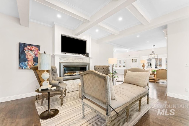 living area featuring a glass covered fireplace, wood finished floors, beam ceiling, and baseboards