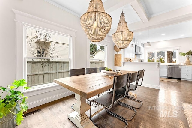 dining space featuring recessed lighting, hardwood / wood-style floors, a healthy amount of sunlight, and an inviting chandelier