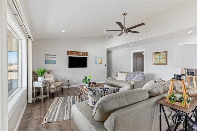 living room with visible vents, a ceiling fan, wood finished floors, baseboards, and lofted ceiling