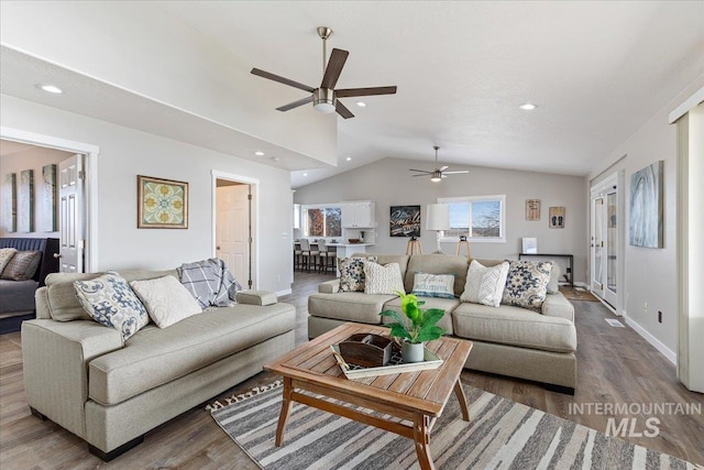 living room featuring vaulted ceiling, wood finished floors, a ceiling fan, and recessed lighting