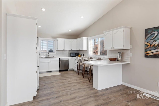 kitchen with dishwasher, white cabinetry, lofted ceiling, and black microwave