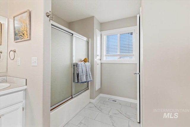 full bathroom featuring enclosed tub / shower combo, marble finish floor, vanity, and baseboards
