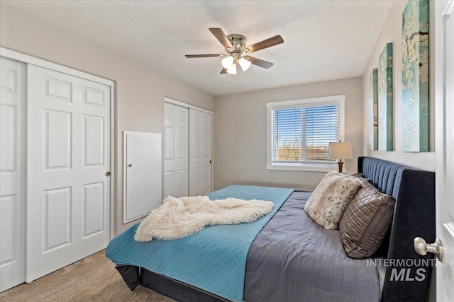 bedroom featuring ceiling fan, carpet floors, and a textured ceiling