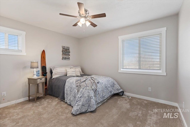 bedroom with multiple windows, carpet flooring, baseboards, and ceiling fan